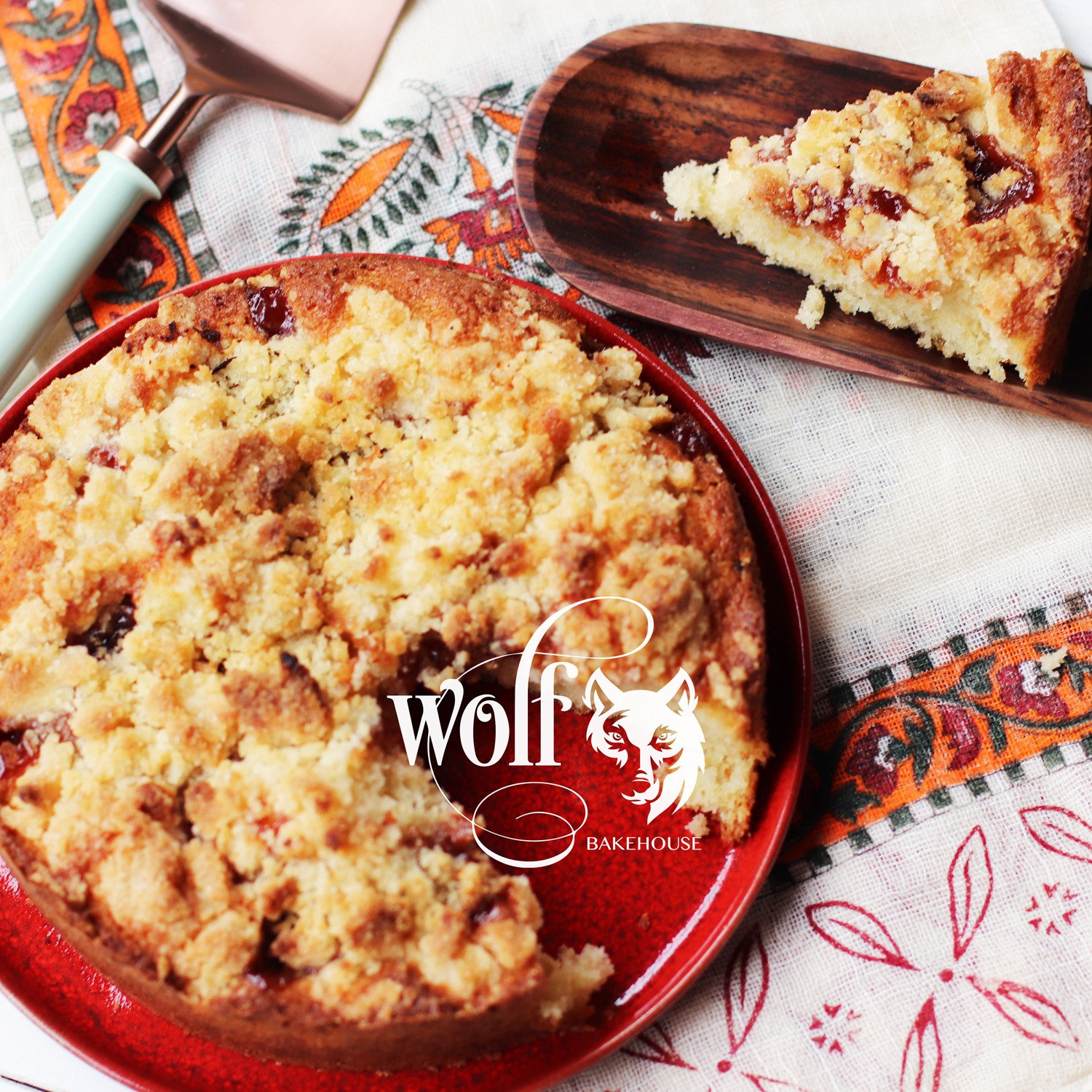 Cuca com farofa doce e frutas vermelhas, com uma fatia separada ao lado