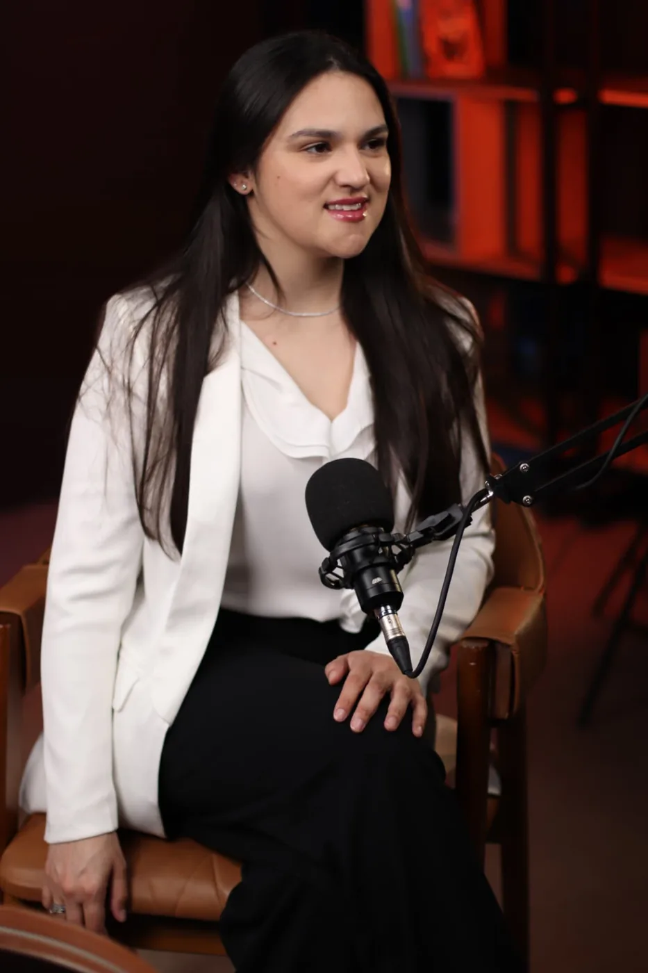 Profissional em blazer branco gravando podcast corporativo